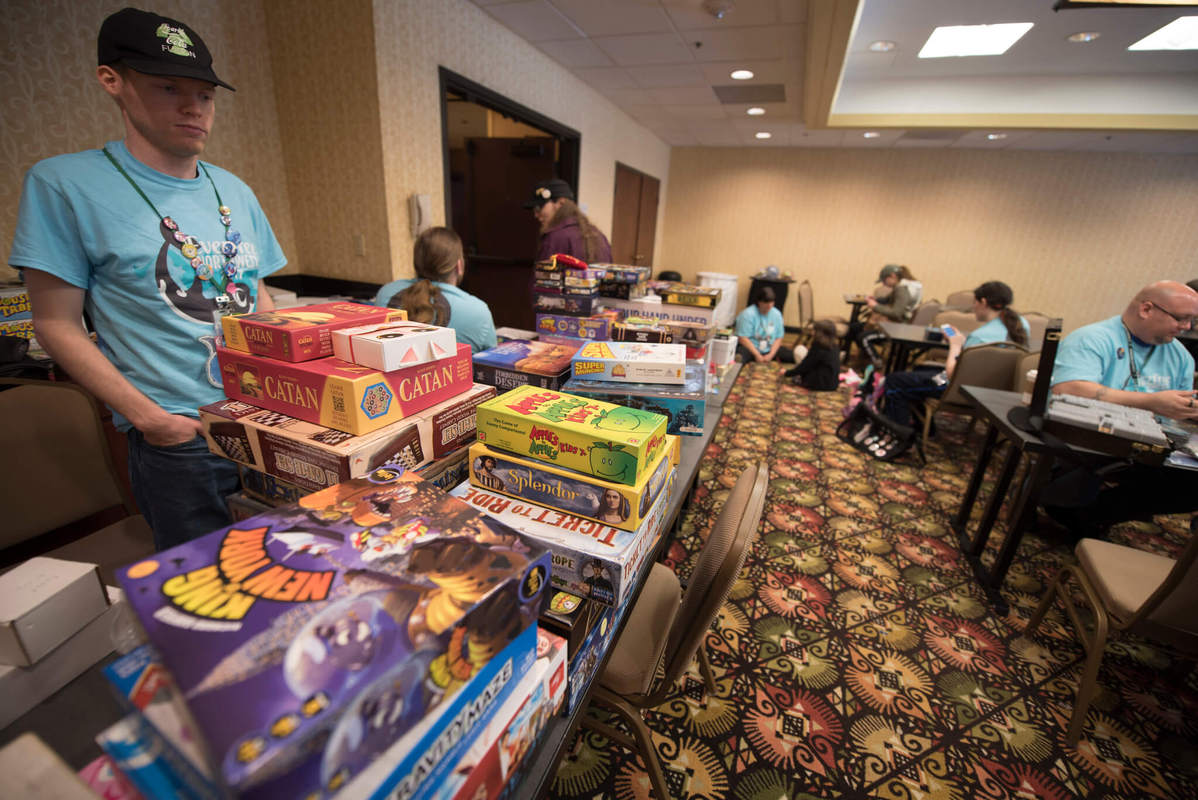 A shelf full of tabletop games in the game room.